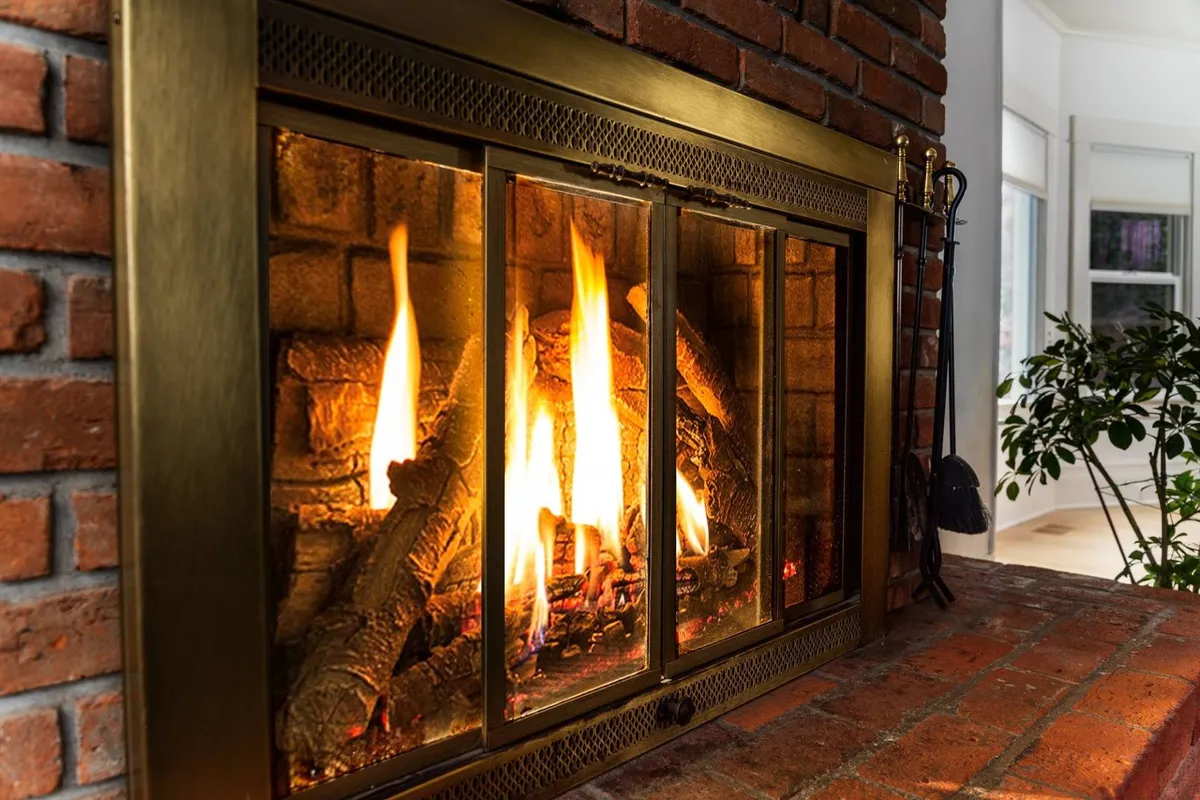 This inviting living area centers on a vibrant fireplace set against a brick wall, with comfortable seating arranged for conversation or relaxation. The scene radiates warmth and is ideal for unwinding after a day of exploring campus or local attractions.