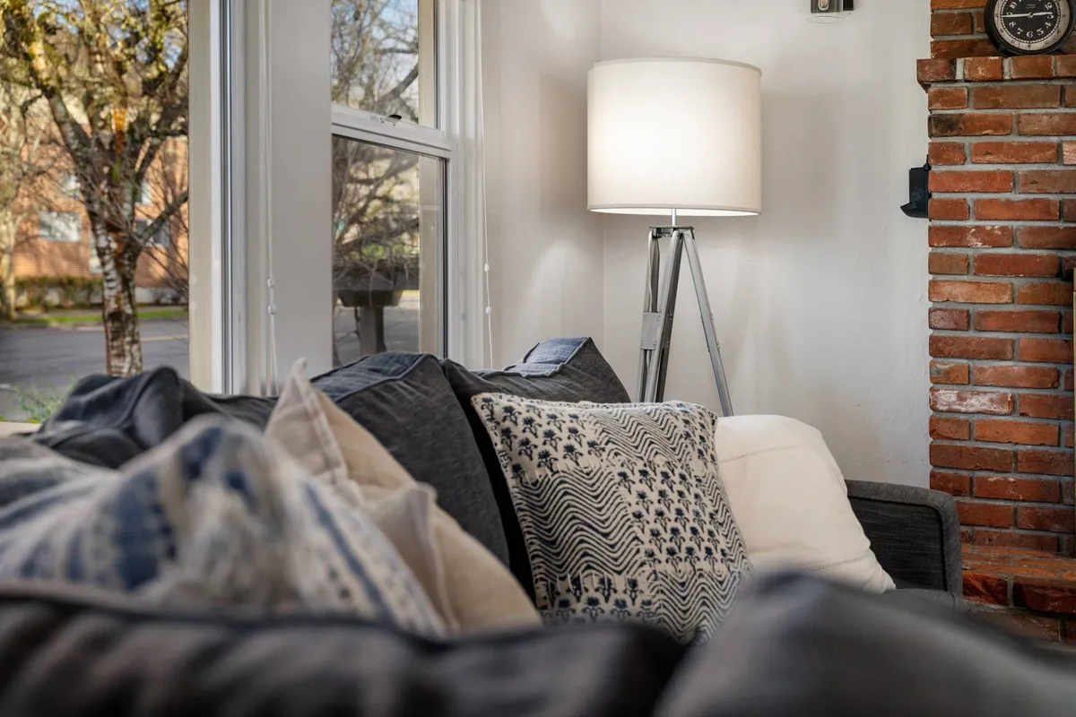 A brick-walled room with a comfy sofa and soft lighting, creating a perfect nook for intimate conversations, reading, or a cozy movie night. The ambiance is inviting and ideal for small groups or family time.